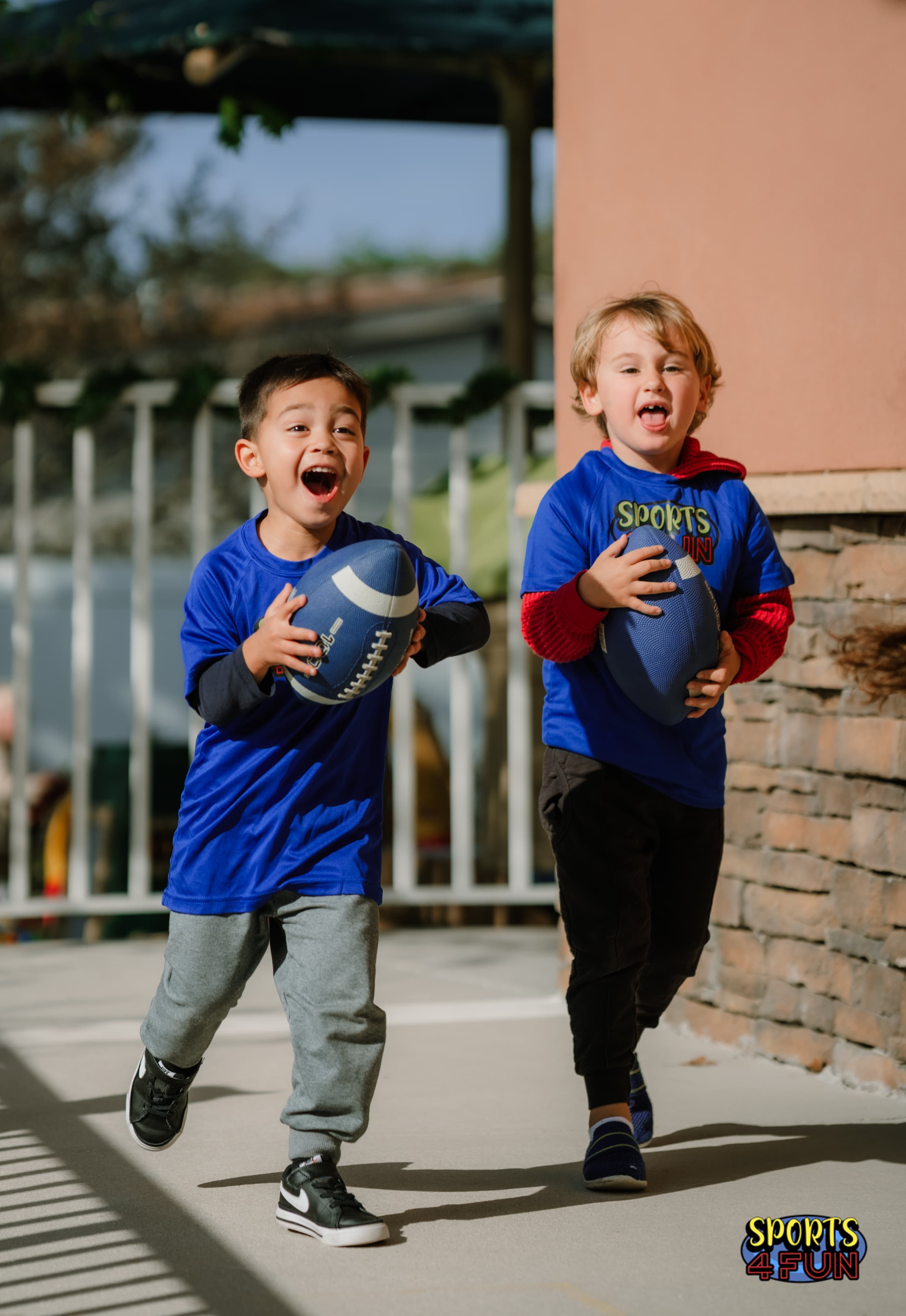 Two children running with footballs in a Sports4Fun multi-sport session