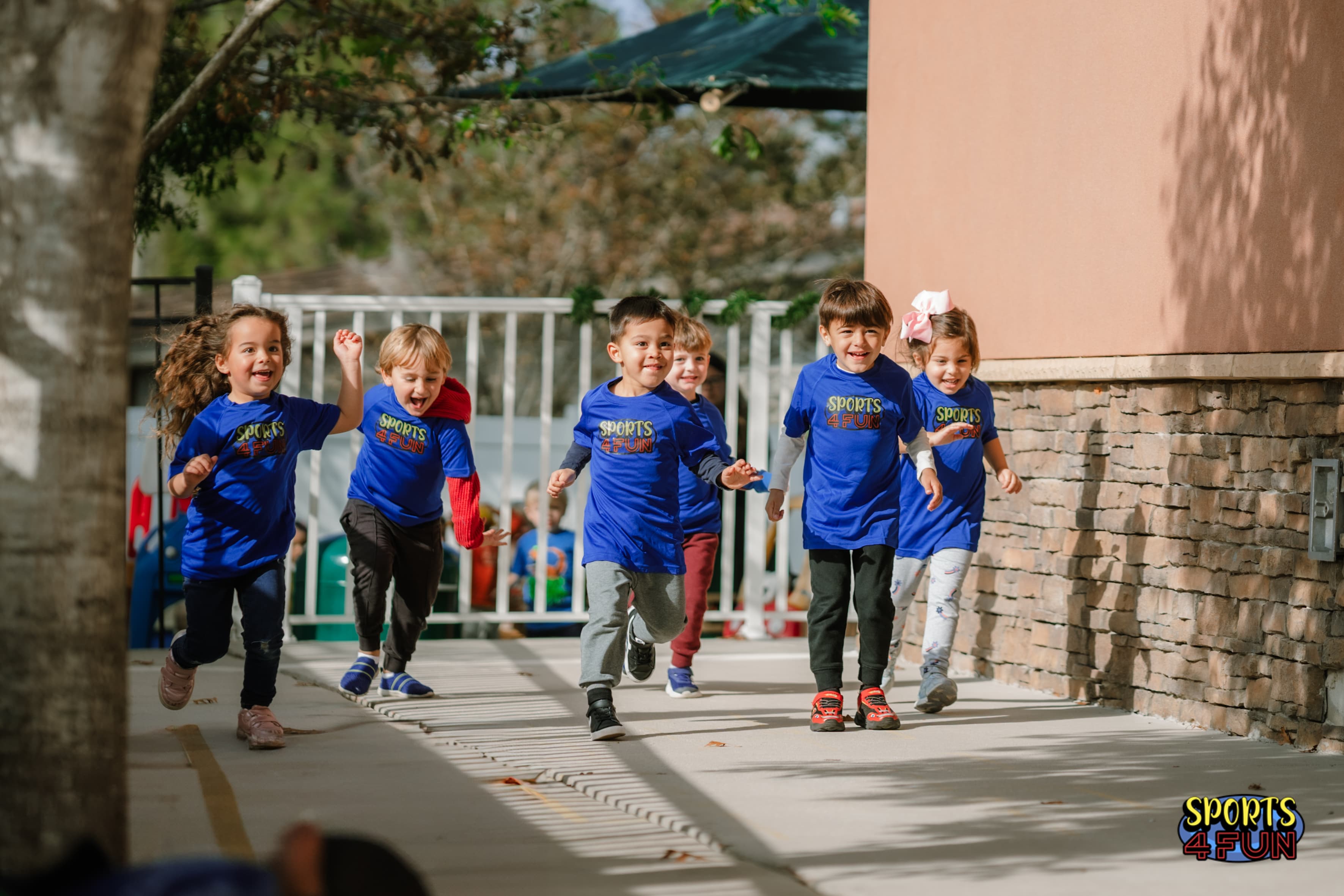 Children in Sports4Fun shirts running joyfully at a school program